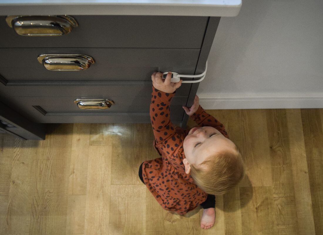 Baby trying to open cupboard with child safety lock